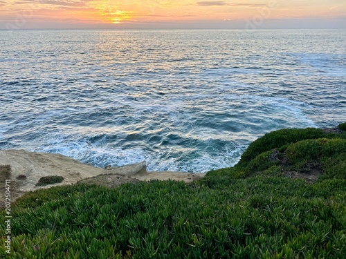 Картината върху платно A serene post-sunset view looking over the Pacific Ocean featuring iceplant-cove