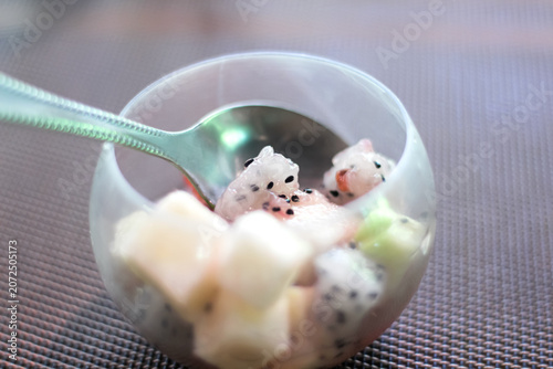 Healthy dragon fruit pieces in glass with spoon on table