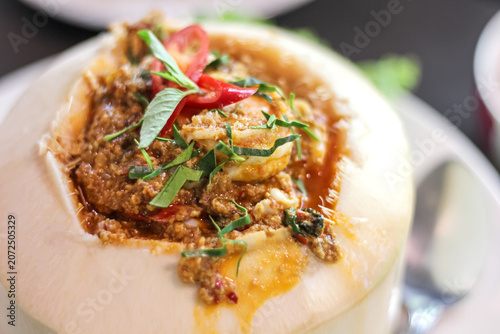 Thai steamed seafood curry in young coconut