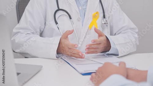 Doctor and patient having a medical consultation for Yellow Ribbon concept of yellow September, Suicide prevention day, Childhood, July Sarcoma, bone and bladder cancer, explaining treatment plan
