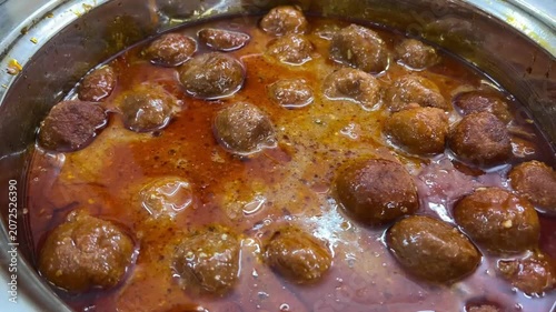 A beautifully presented dish of rich and creamy Malai Kofta, garnished with fresh cream and nuts, served at an elegant vegetarian marriage celebration in India.