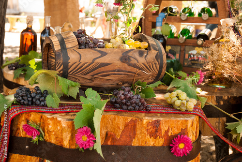 Decorative Wine Bottle Display with Grapes, Vine Leaves and Flowers