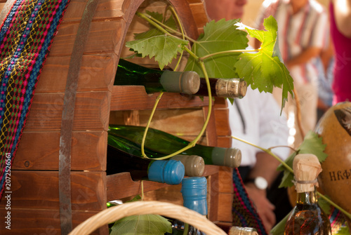 Wine Bottles Displayed in Rustic Wooden Rack with Grape Leaves