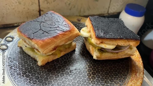 A spectacular close-up shot of a crispy, golden-brown potato dumpling layered inside a soft pav bun, perfect for authentic fast-food restaurant menus.