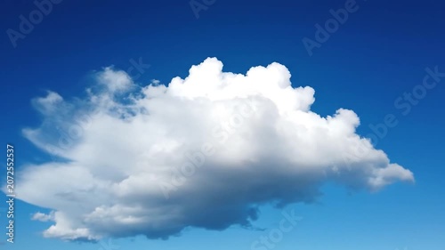 Fluffy white cumulus clouds float in a deep blue sky