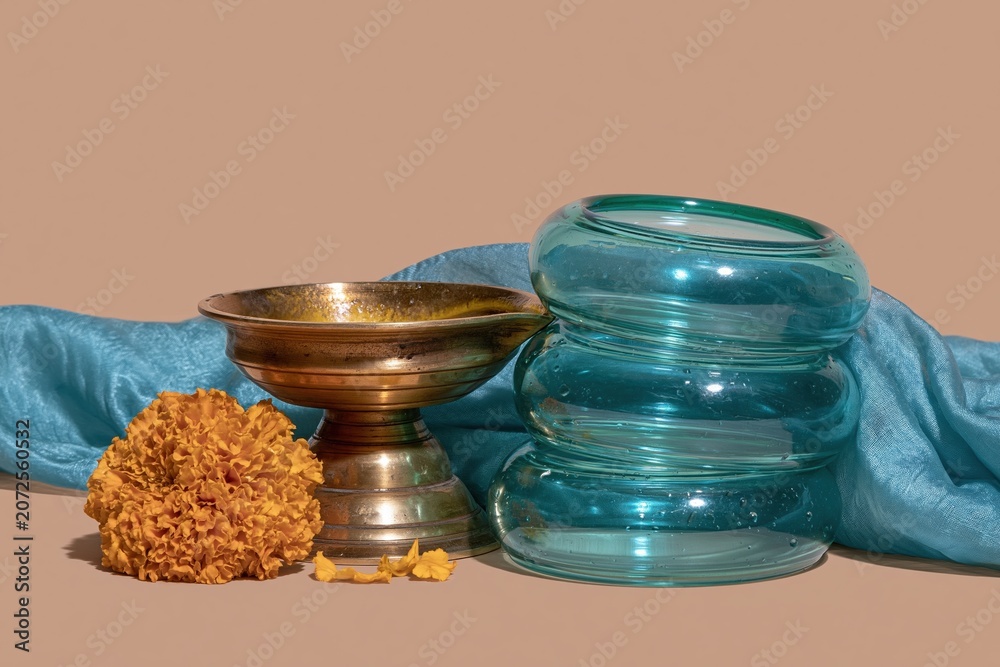 Fototapeta premium Polished brass diya and green glass bangles for Hariyali Teej festival, featuring a silk saree and orange marigold for cultural greeting card layouts