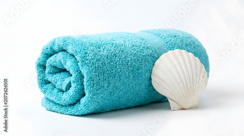 A rolled turquoise blue cotton towel with a white seashell on a white background.
