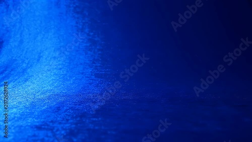 Abstract Blue Light Reflection on Dark Textured Surface.