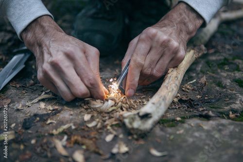 Quadro em tela A man tries to make a fire with an angle