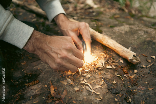 Photography A man tries to make a fire with an angle