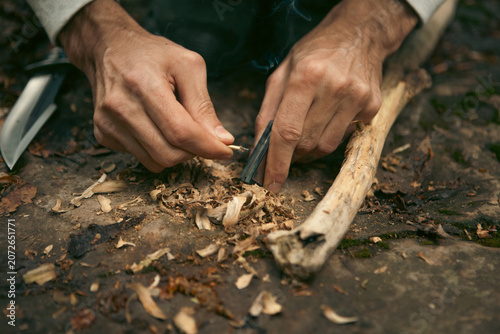 Quadro em tela A man tries to make a fire with an angle