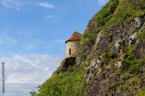 The dome of the church of the Elia Monastery at the foot of the cliff. The walls are made of light stone, the roof is tiled. Elia, Kakheti, Georgia