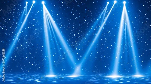Vibrant blue spotlights illuminate a sparkling stage with falling particles.