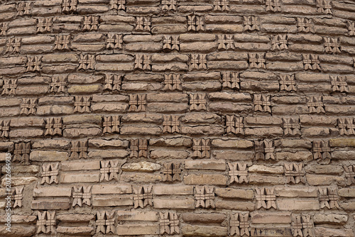 Decorative brickwork detail of the Kalyan minaret in Bukhara with carved cross-shaped ornamental inserts. Ideal for architectural texture backgrounds and heritage publications.