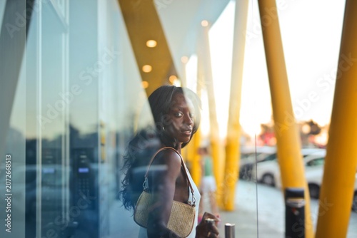 Quadro em tela Stylish woman looking back through glass reflection