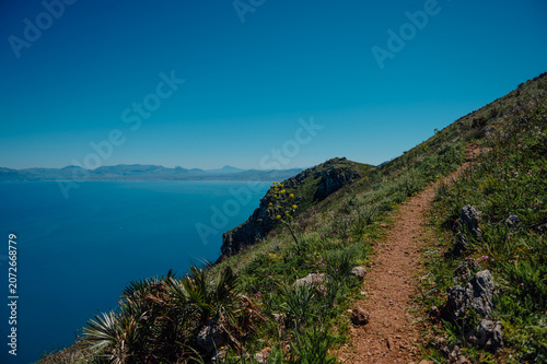 Dirt path on a green cliff overlooking the Mediterranean Sea, Zingaro