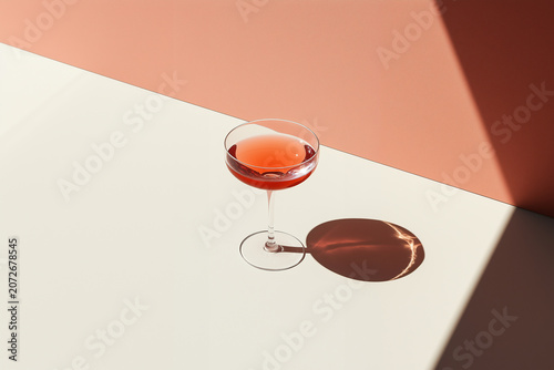 Pink artisan cocktail emphasizing a minimalist textural study of translucent fluid dynamics.