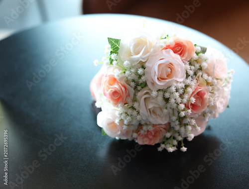 A bouquet of pink and white flowers was placed on a black wooden table.