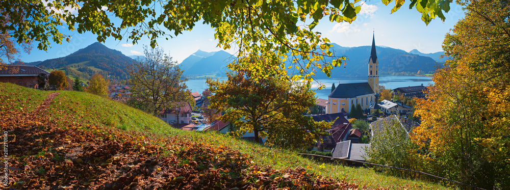 Obraz premium autumnal panorama tourist resort Schliersee. view to Church, lake, village and mountains
