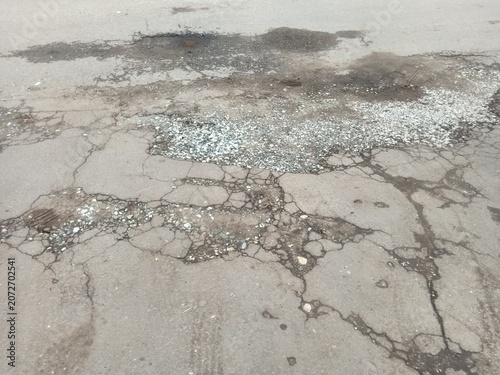 Foto Potholes and cracks on deteriorating asphalt road surface