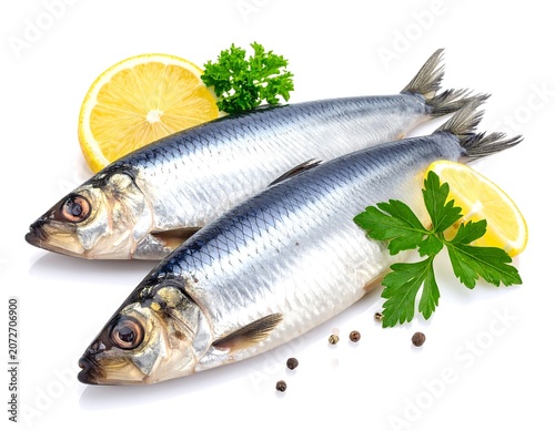 Two raw fish with lemon, parsley, and peppercorns on white background