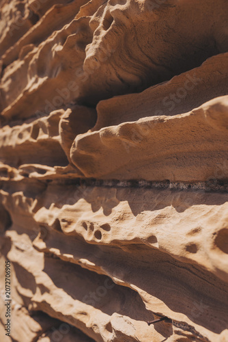 Natural patterns of sandstone reveal the stories of time and erosion in the sunlight of a warm afternoon