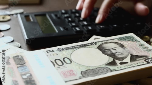 黒い計算機でお金を計算する　札束　貯金　資産運用　投資