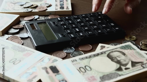 黒い計算機でお金を計算する　札束　貯金　資産運用　投資