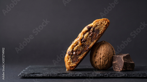 Gourmet Walnut Chocolate Chip Cookie with Caramel Drizzle and Dark Chocolate on Slate