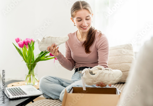 фотографія Girl Looking At Sneakers Bought Online And Shopping Online
