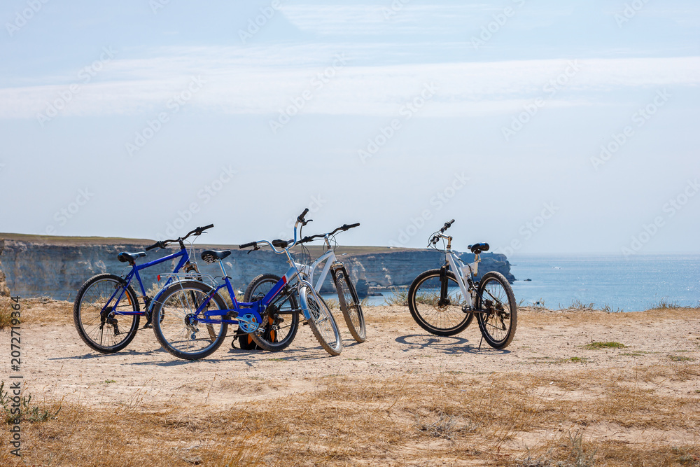 Fototapeta premium Three Bicycles Parked on Sea Cliff under Blue Sky in Summer