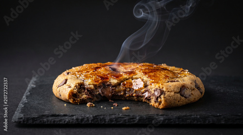 Steaming Hot Chocolate Chip Cookie with Melting Chocolate on Slate