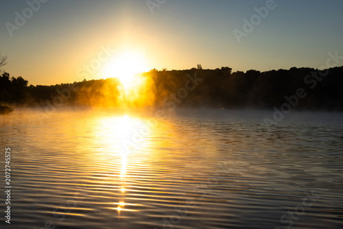 Принти на полотні A low sun meets the water and throws a striking reflection toward the viewer whi
