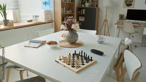 Chessboard, flower vase, and snacks resting on table in empty retirement home common room. Video for promoting senior care, assisted living, and elderly recreation programs