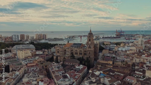 Drone view of Malaga Cathedral, historic city center and Mediterranean port in Malaga, Andalusia, Spain. Scenic skyline with marina, cruise ships and harbor at sunset.