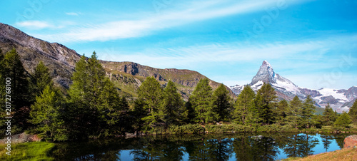 Matterhorn mountain rising above alpine lake and forests near Zermatt, Switzerland