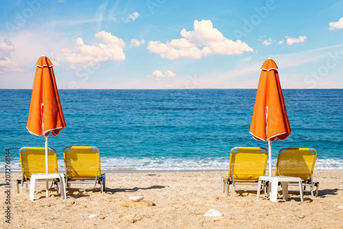 orange beach umbrellas and sunbeds on sandy mediterranean beach