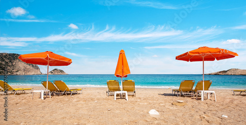 Beautiful summer landscape with Petani Beach and sun loungers for sunbathing on the coast of the Ionian Sea in Kefalonia, Greece. Amazing places. Tourist Attractions.