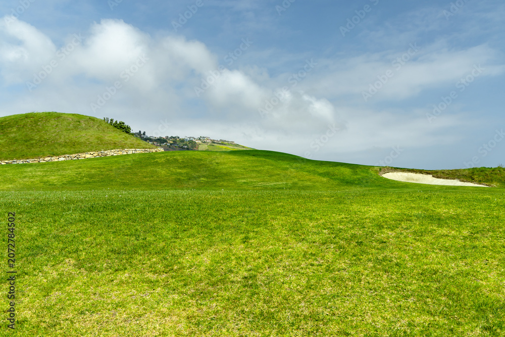 Obraz premium Green grass hill under blue sky minimal landscape background