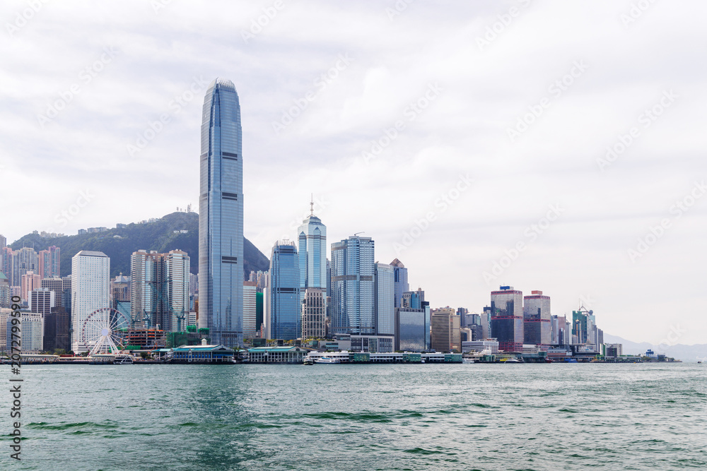 Obraz premium Hong Kong skyscraper panorama on a sunny day with water and boats
