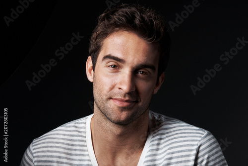 Confident, man and designer in studio with smile, career pride and about us for clothes launch. Portrait, person or entrepreneur with ambition, positive attitude and apparel tailor on dark background