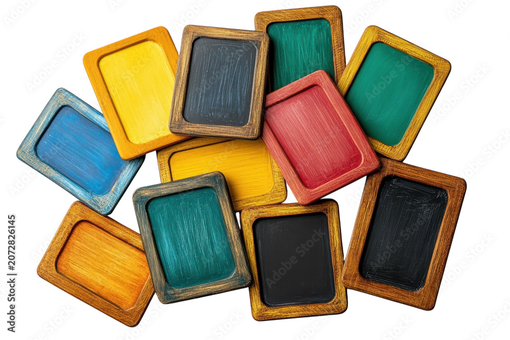 Fototapeta premium A collection of various colorful wooden rectangular chalkboard frames arranged in a messy pile with vibrant painted surfaces and rustic textured edges on white background