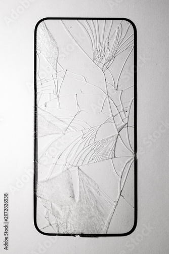 Close-up of shattered smartphone screen with spiderweb-like cracks