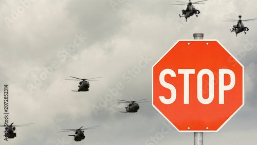 Stoppschild mit Militärhubschrauber im Hintergrund