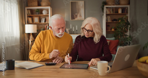 Foto Couple sits at a wooden table in their living room