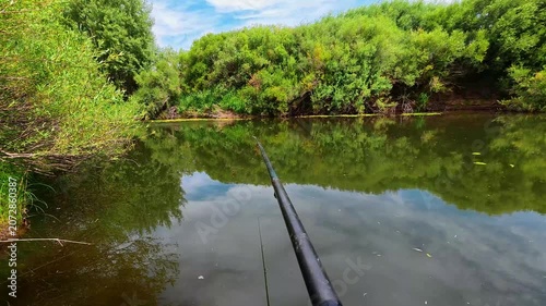 Fishing Rod Over Calm River Surrounded by Green Nature, First Person View, 4K