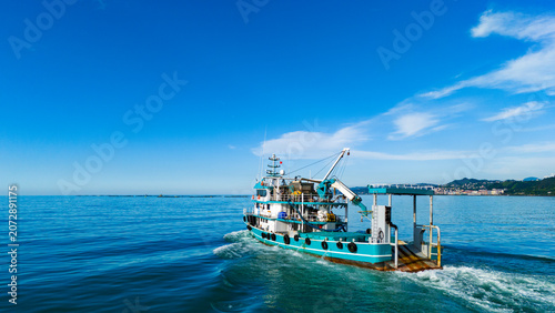 Aerial view of a well equipped commercial fishing boat navigating the calm ocean waters