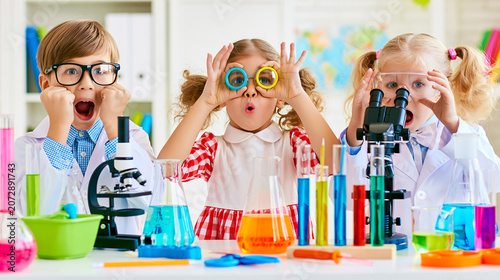 Kids wearing lab coats making funny faces, discovering scientific principles in a playful learning environment