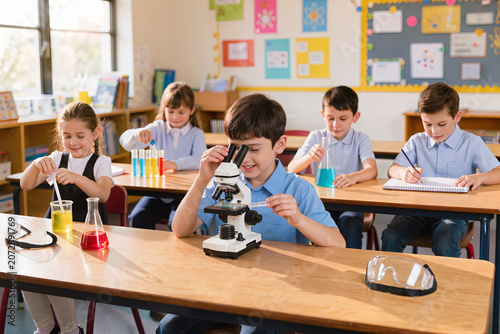 Group of smiling children engaging in a hands on science lesson, performing experiments with chemical apparatus and a microscope in school