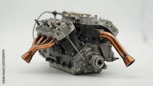 Detailed scale model of a combustion engine with copper exhaust pipe isolated on white background
